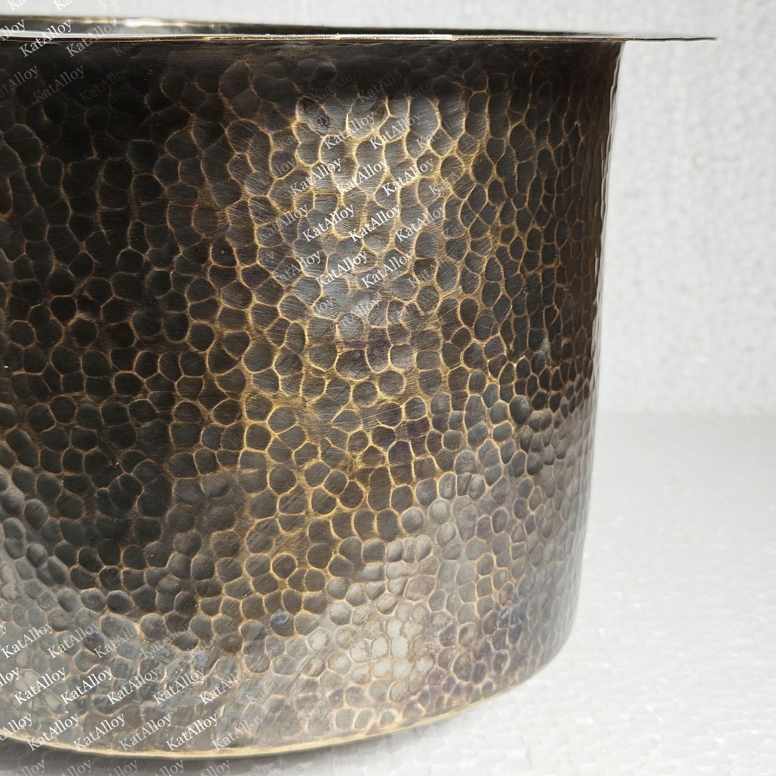 Close-up of a metal pot with a textured surface on a white background