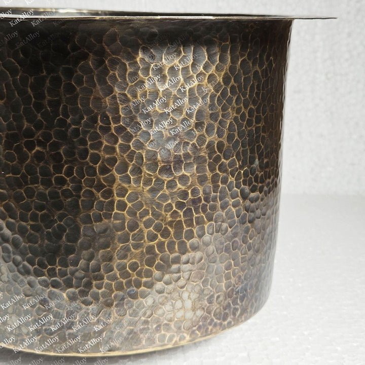 Close-up of a metal pot with a textured surface on a white background