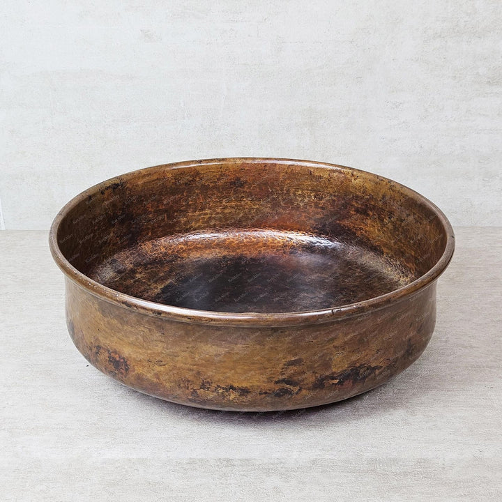 aged copper bowl on a textured gray background