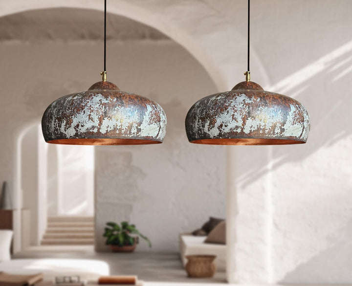 Two rustic pendant lights hanging in a room with a neutral color palette.