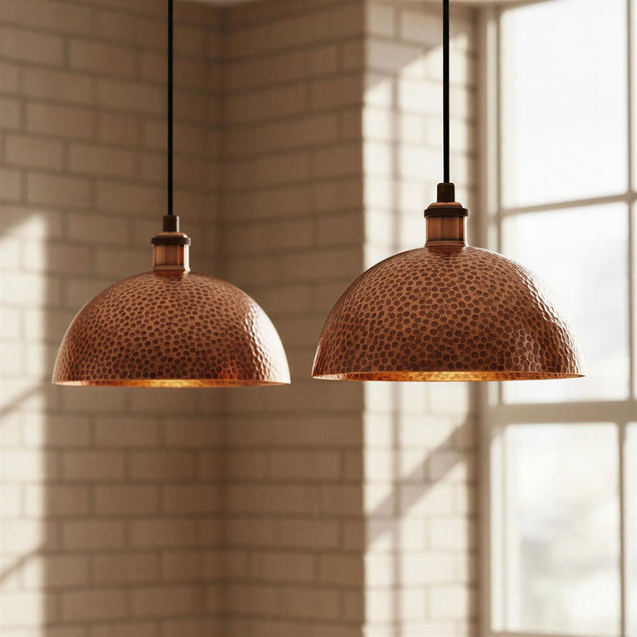 Two copper pendant lights hanging in a room with sunlight streaming through a window.