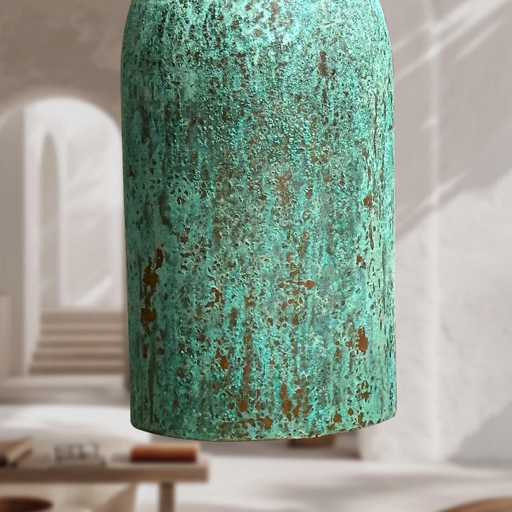 Textured green vase on a blurred indoor background