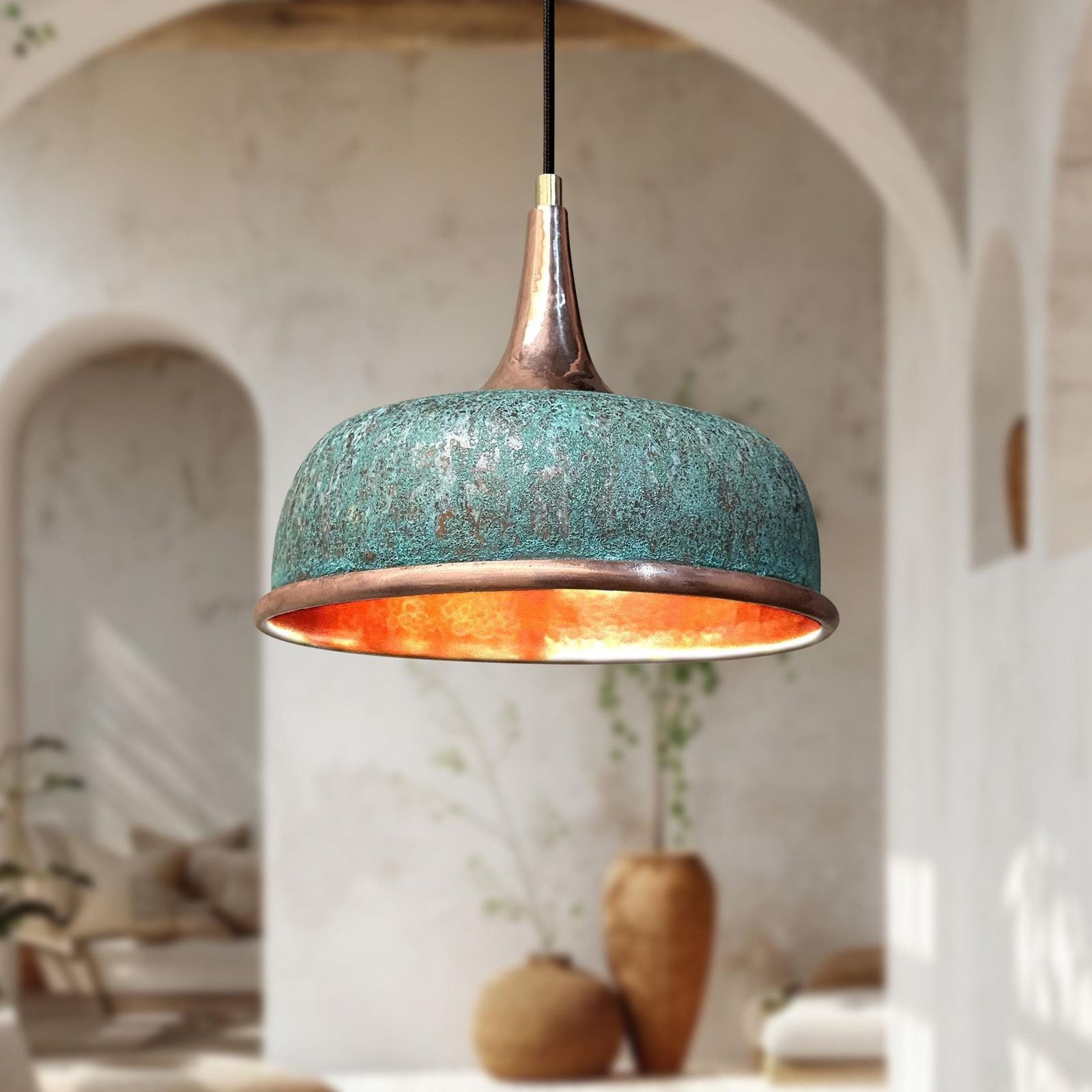 Turquoise pendant light with a warm glow in a softly blurred indoor setting