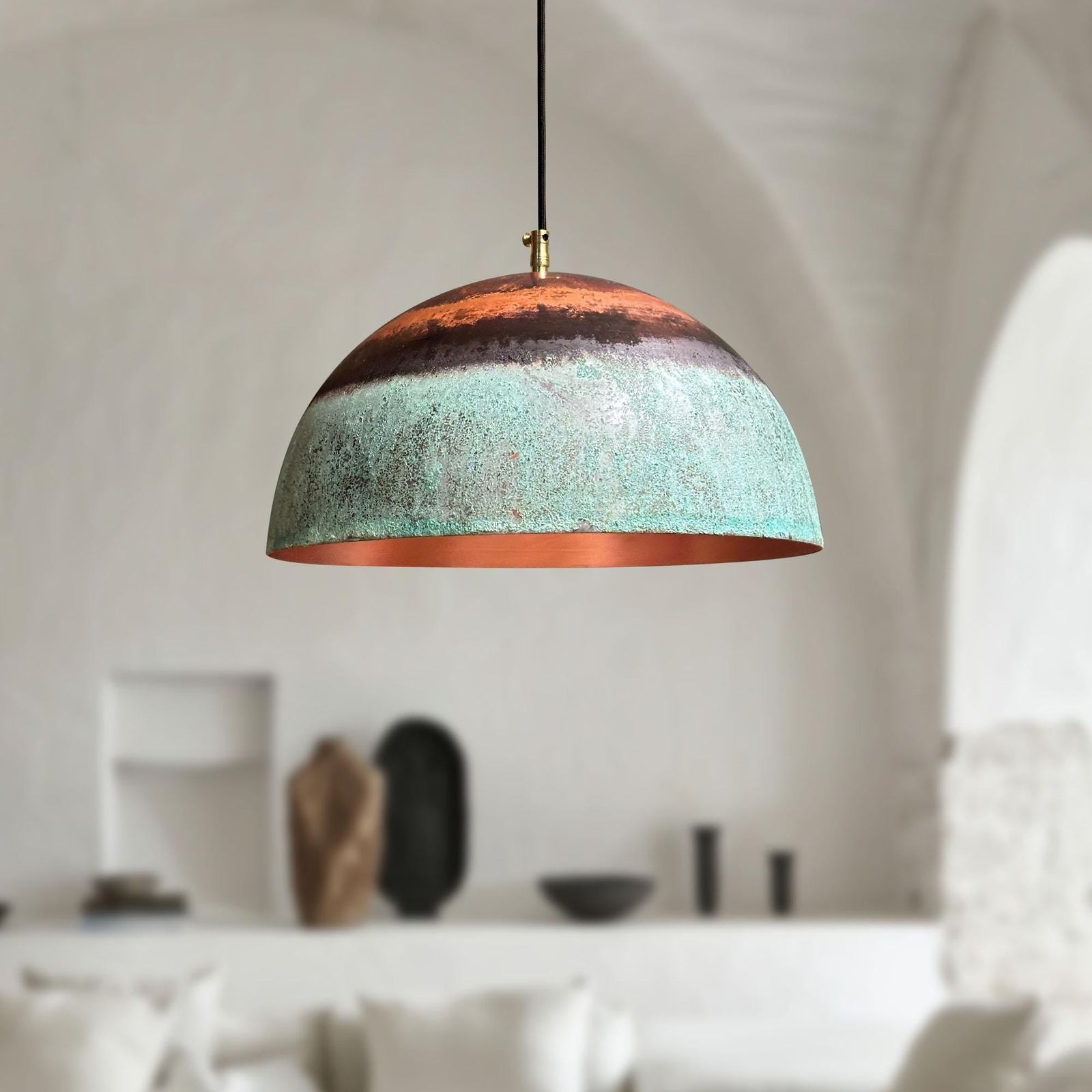 Modern pendant light with a textured design hanging in a room with neutral decor.