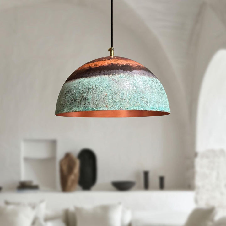 Modern pendant light with a textured design hanging in a room with neutral decor.