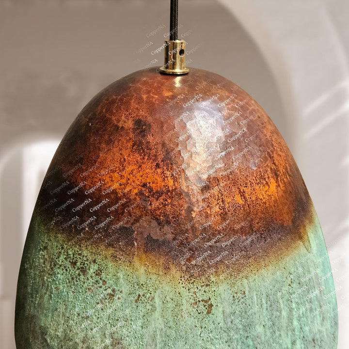 Close-up of a textured, multicolored pendant light with a white background
