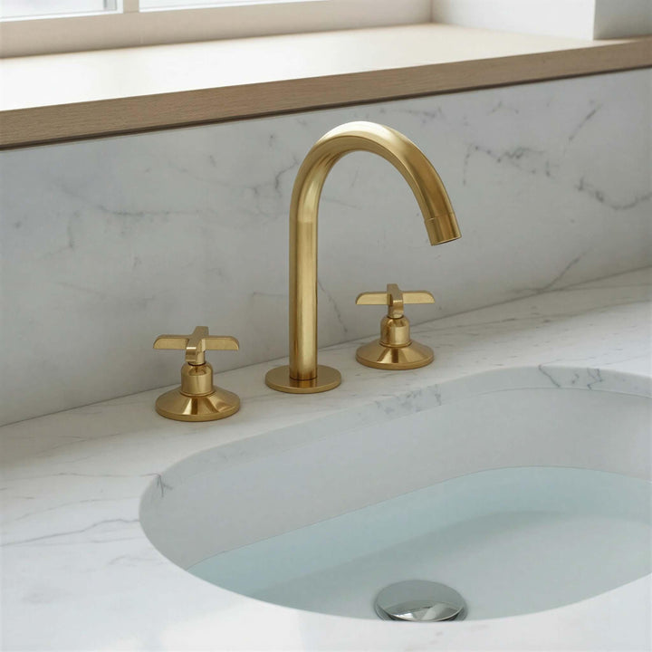 Gold faucet and handles on a marble sink