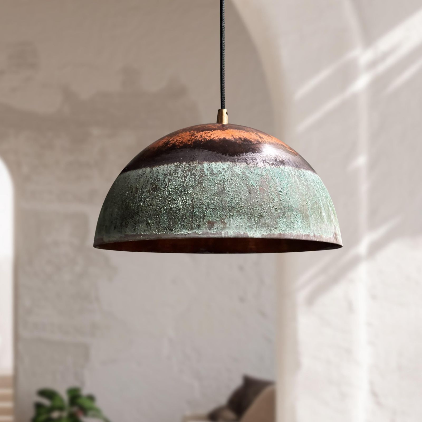 Dome-shaped pendant light with a textured surface in a softly lit room.