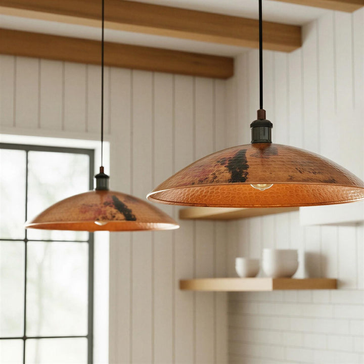 Two pendant lights hanging in a room with wooden beams and a window.