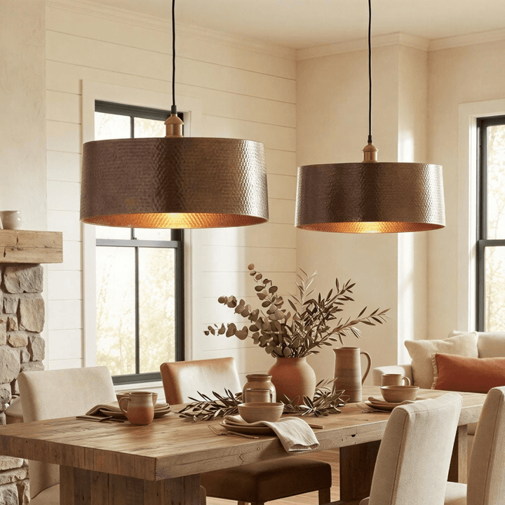 Dining room with wooden table, chairs, and two pendant lights.