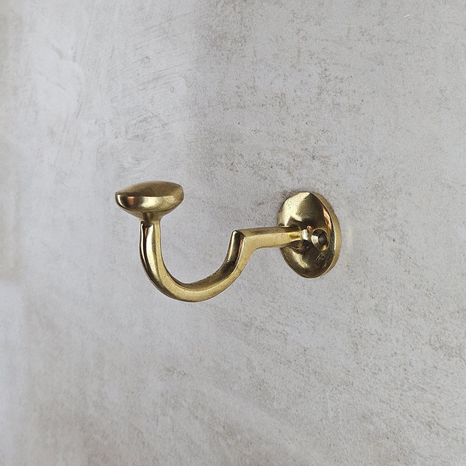Gold wall hook on a gray concrete wall