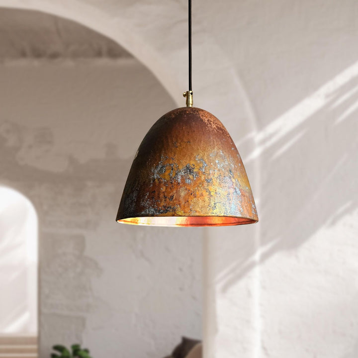 Rust-colored pendant light hanging against a neutral wall.
