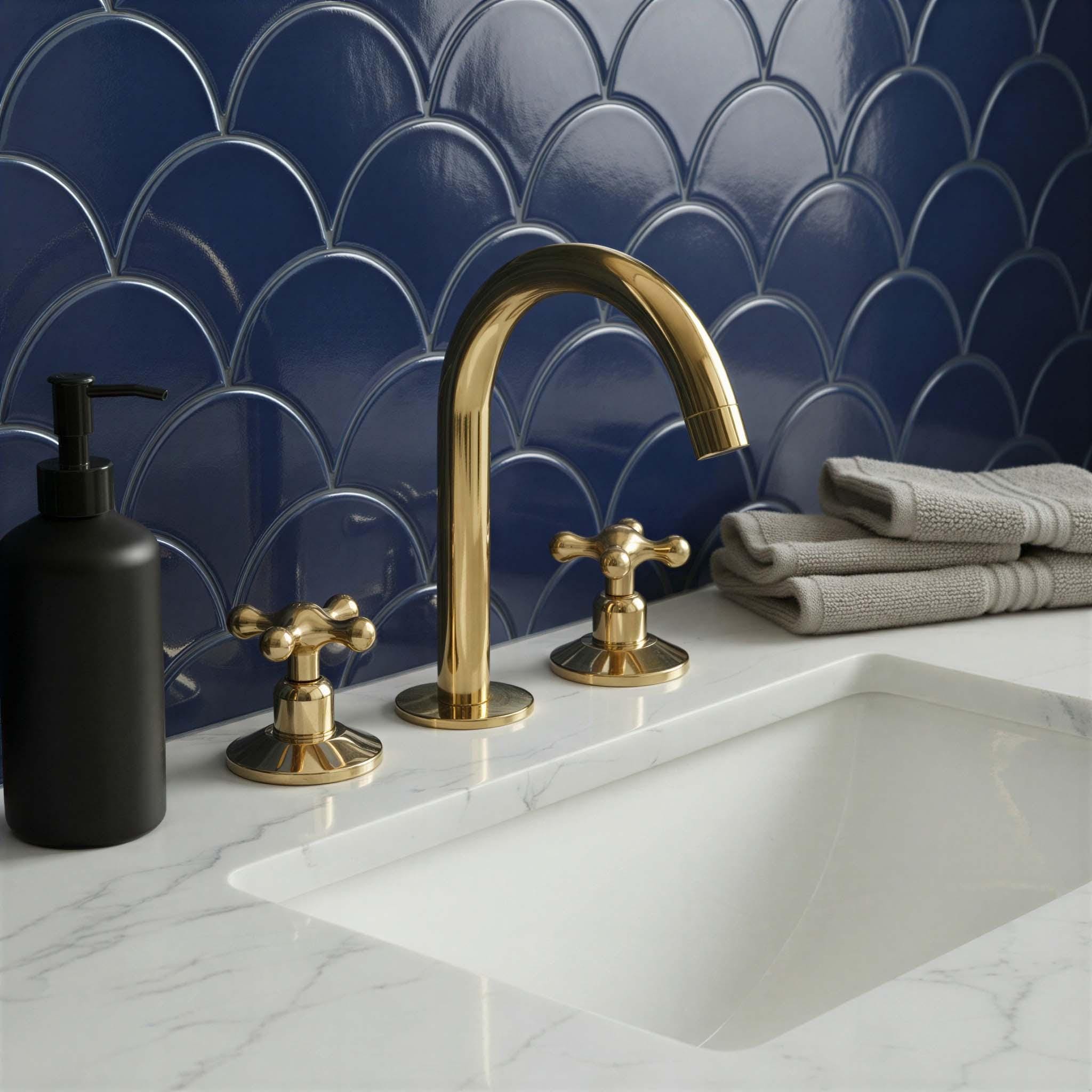 Bathroom sink with gold faucet and black soap dispenser against a blue tiled wall.