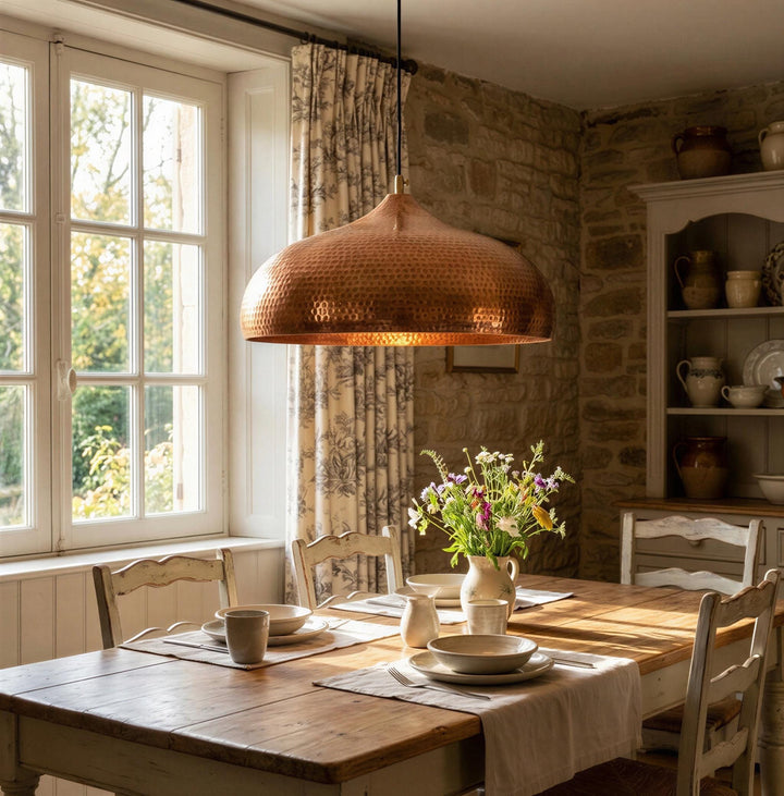 Dining room with wooden table, chairs, and a copper pendant light.