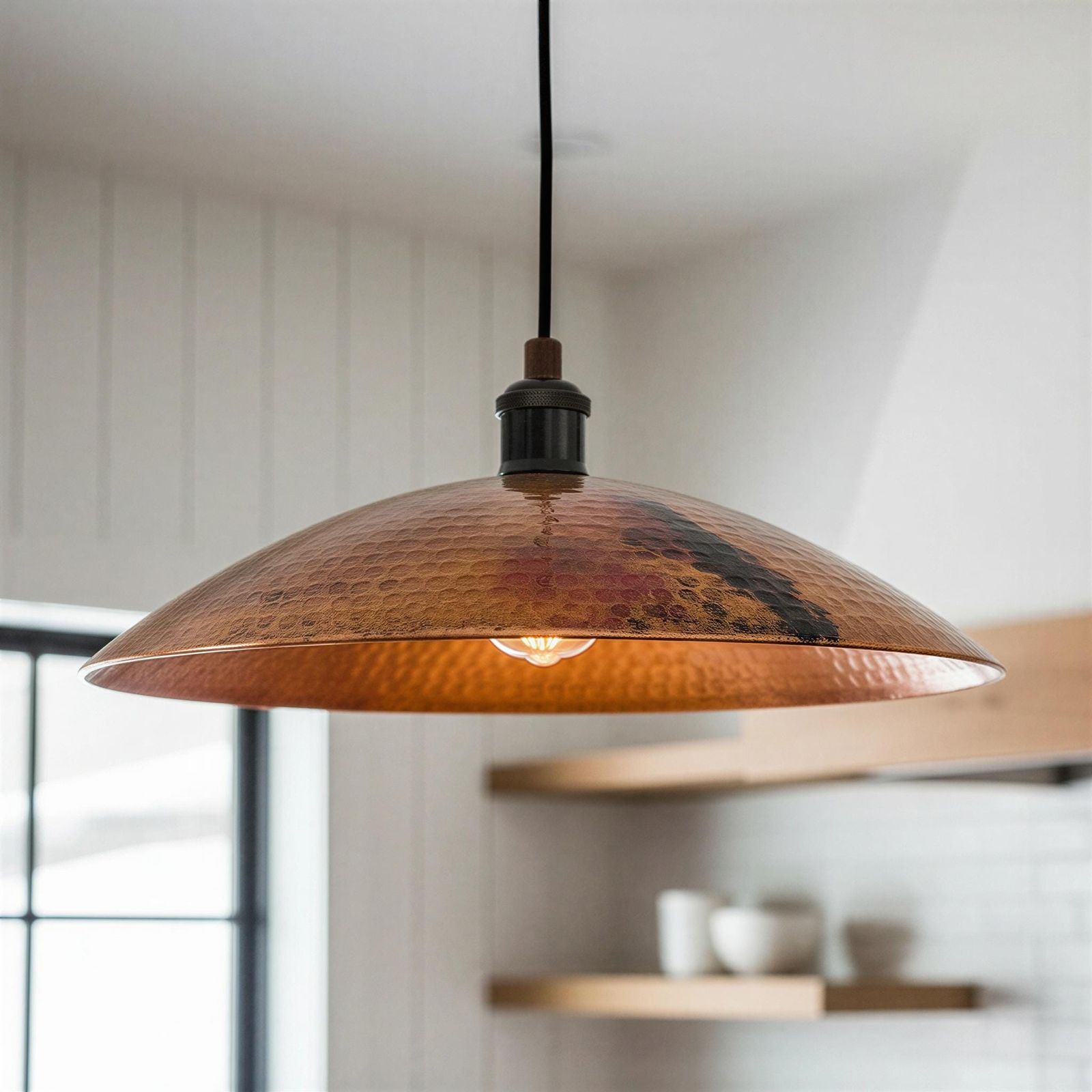 Copper pendant light hanging in a room with a blurred background