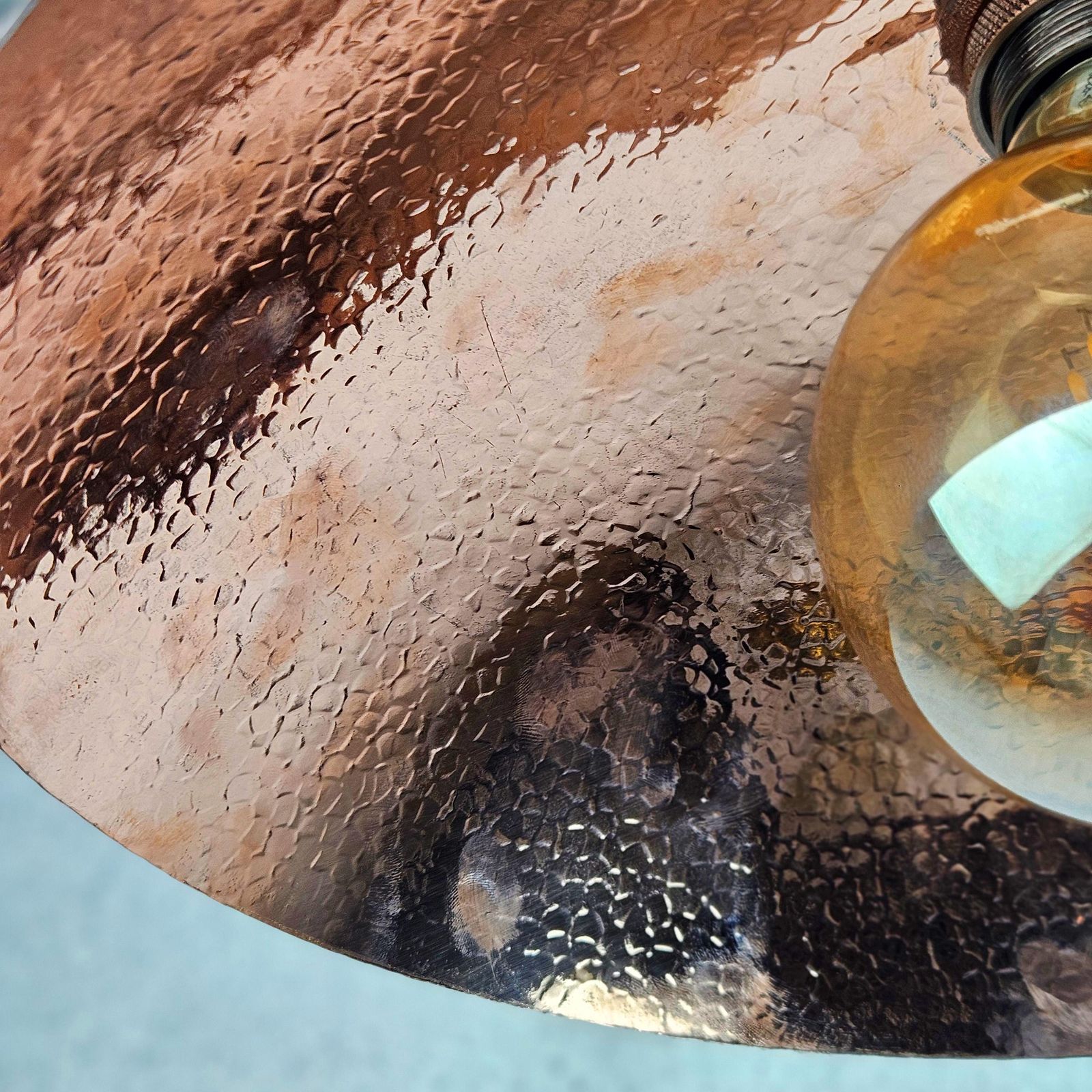 Close-up of a textured copper surface with a light blue background